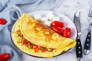 Fried omelette with beef, tomato, onion and herbs. Delicious breakfast with scrambled eggs photo