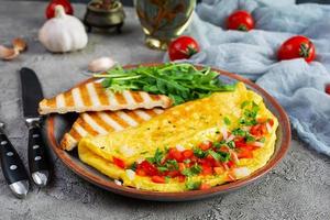 Fried omelette with tomatoes, onion and herbs. Delicious breakfast with eggs and toasts photo