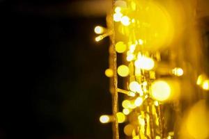Closeup blurred and bokeh of Christmas lights and refection lighting on black background. photo
