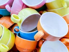 Closeup and crop colorful heap of ceramic coffee cup fit on screen background and wallpaper. photo