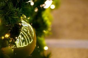 primer plano bolas de navidad doradas decoradas en pino el día de navidad con bokeh de iluminación led y fondo borroso. foto