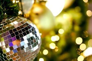 Closeup crystal of Christmas Balls Decorated on Pine Tree on Christmas day with blurry and bokeh of Christmas lighting background . photo