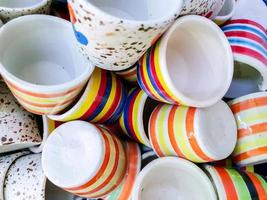 Closeup and crop heap of colorful striped and spread ceramic coffee cup fit on screen background and wallpaper. photo