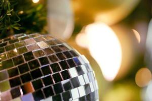 primer plano de cristal de bolas de navidad decoradas en pino el día de navidad con borroso y bokeh de fondo de iluminación de navidad. foto