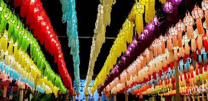 panorama colorido y vista en perspectiva de linternas de estilo lanna tailandés para colgar frente al templo en la noche en el festival de loy kratong. foto