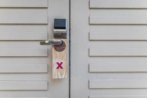 Hotel electronic card lock with do not disturb sign. Modern stainless with card insert handle on wood door photo