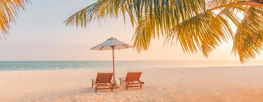 Dream scene. Beautiful palm tree over white sand beach, two sun chairs, loungers near sea. Wonderful summer nature view, tropical landscape. Panoramic scenery for vacation and holiday background photo