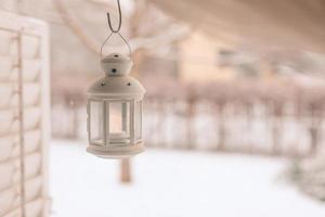 linterna de hierro blanco sobre un acogedor y maravilloso fondo invernal. tonos cálidos en la fría escena invernal, vistas relajantes y tranquilas. fondo de invierno perfecto, feliz navidad y felices fiestas copia espacio foto