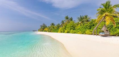 tranquilo paisaje de playa. panorama de playa tropical exótico para fondo o papel tapiz. increíble paisaje de verano, aguas tranquilas y palmeras bajo el cielo azul y arena blanca. concepto de vacaciones y vacaciones foto