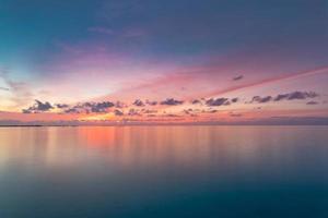 Sunset beach, romantic colors of sky and sea water reflection with horizon. Summer tropical landscape, vacation and holiday destination concept. Inspirational beach sunset for background or wallpaper photo