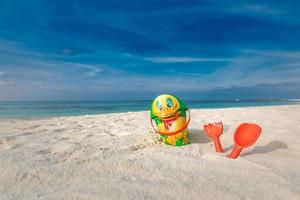 Children's beach toys - buckets, spade and shovel on sand on a sunny day. Topical island beach holiday, tourism background. Cute beach toys