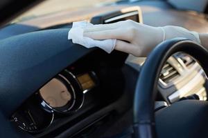 Woman cleaning car dashboard with a disinfection spray photo