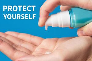 Woman hand using wash hand hygiene gel pump dispenser on a blue background, female skin care photo