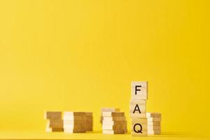 Wooden blocks with word FAQ on the yellow baclground. photo