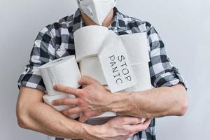 Man in protecive mask hold a tissue toilet paper rolls photo