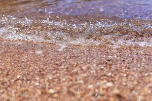 Sea wave on the sand beach, soft focus. Summer background photo
