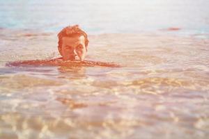 Man relaxing in swimming pool, toned photo