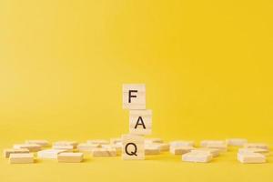 Wooden blocks with word FAQ on the yellow baclground. photo