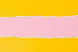borde de papel rasgado con un espacio de copia, fondo de color rosa y amarillo foto