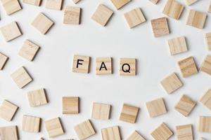 Wooden blocks with abbreviation FAQ on the white background, top view. Frequently asked questions concept photo