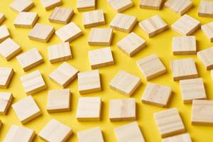 Empty wooden blocks pattern on the yellow background, top view photo