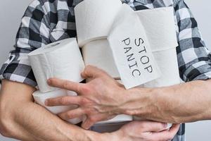 Man in protecive mask hold a tissue toilet paper rolls photo