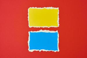 Two ripped paper torn edge sheets on a red background. photo