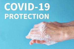 concepto de protección de la salud del brote de covid-19 con el antiséptico. la mujer se lava las manos con desinfectante o gel antiséptico como medida de prevención del coronavirus con fondo azul foto