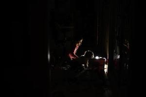 Sisters playing at home during a blackout using alternative lighting with solar panel. photo