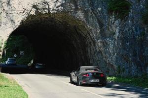 mazda mx 5 en road rocky tunnel en bled, eslovenia. foto