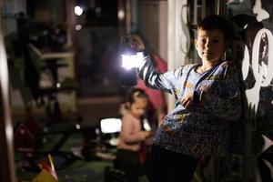 Boy at home during a blackout using flashlight lantern. photo