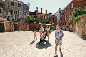 Woman with kids walk in Campiello Novo O Del Morti street in Venice, Italy. photo