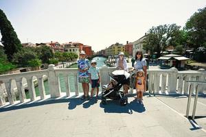 Family stand on bridge of canal in Venice, Italy. photo