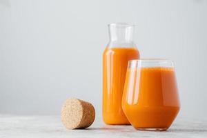 Glasses of fresh pressed carrot juice on white background. Homemade beverage for your healthy drink. Delicious drink full of vitamin C. photo