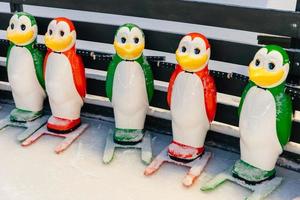 Shot of special equipment needed for skating, helping people to keep balance on ice rink. Helpers for skater beginners. Colourful figures in form of penguins photo