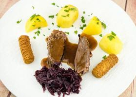 roasted goose with potatoes red cabbage and brown gravy photo