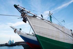 the front side of a large fishing boat moored in the harbor. anchor hanging, seen from below photo