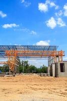 Heavy Steel Structural Gantry Crane for moving large slabs in a dangerous slab casting factory is being built strong and stable against a beautiful evening sky background. photo