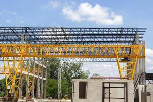 Heavy Steel Structural Gantry Crane for moving large slabs in a dangerous slab casting factory is being built strong and stable against a beautiful evening sky background. photo