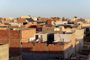 Cityscape view of Tozeur city in Tunisia during sunset with minarets of mosque in the background. Medina of Tozeur, old city. Place of historic interest. Travel and tourism in the area of the desert. photo