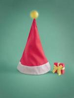 Santa's hat with glowing bulb on the top. Creative minimal Christmas concept. Vibrant green and red colors. photo