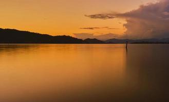 Bay landscape. Long exposure and a blurred background with a view of the sea and mountains illuminated by the sun at sunset. Idea for screensaver or wallpaper photo