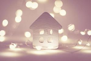 Small house with Christmas garland lights, winter holidays, wintertime mood photo