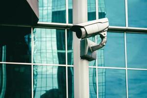 cctv camera - surveillance camera outside of glass building wall photo