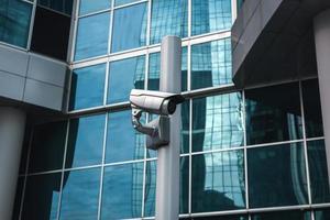 External surveillance camera against glass building facade photo