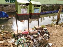 realmente irónico... hay un bote de basura pero la basura se está acumulando debajo foto