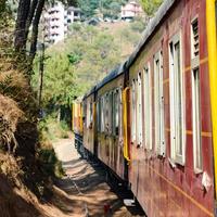 Toy Train moving on mountain slopes, beautiful view, one side mountain, one side valley moving on railway to the hill, among green natural forest. Toy train from Kalka to Shimla in India, Indian Train photo