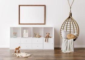 Empty picture frame on white wall in modern child room. Mock up interior in scandinavian, boho style. Free, copy space for your picture. Console, rattan armchair, toys. Cozy room for kids 3D rendering photo