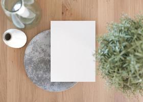 White vertical flyer mock up with home accessories on the table. Paper sheet, blank template for your design. Top view, close-up. Brochure, menu card, invitation presentation. 3D rendering. photo