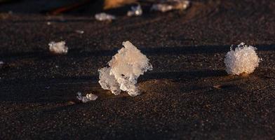 costa del mar báltico con guijarros y hielo al atardecer foto